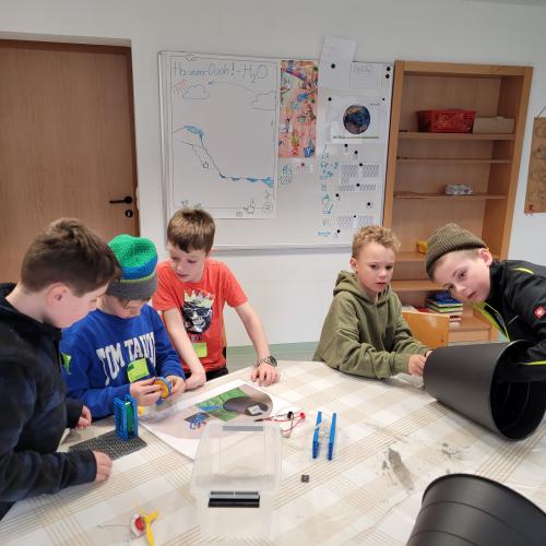Kinder bauen ein kleines Wasserkraftwerk