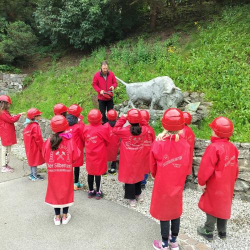 Kinder mit Helm hören eine Geschichte