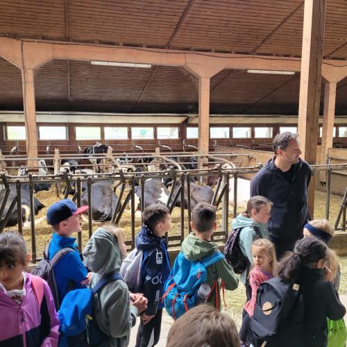 Bauer hans Jörg erklärt den Kindern etwas im Stall