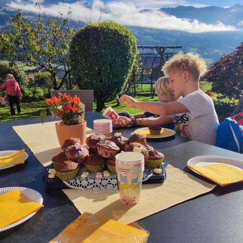 Kinder sitzen am Tisch im Garten