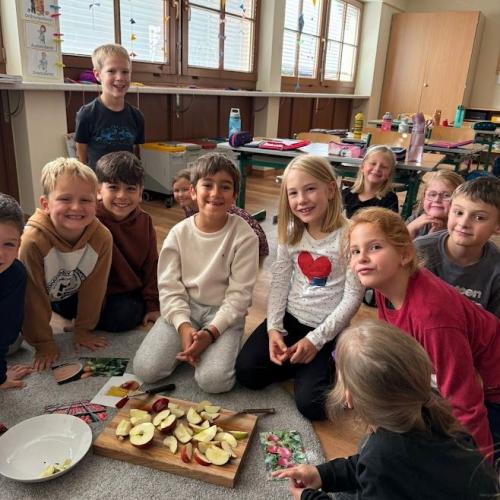 Kinder schneiden einen Apfel