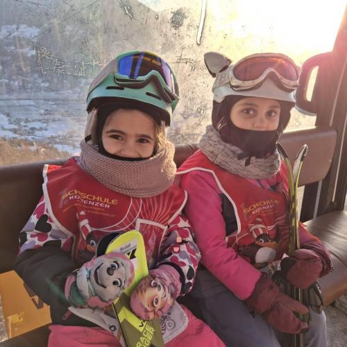 Kinder mit Ski in Gondel