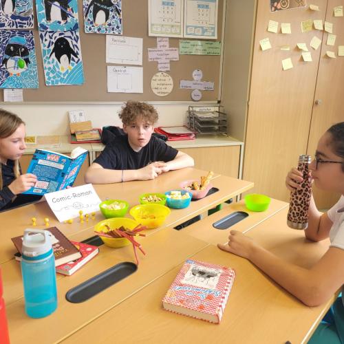 Kinder lesen an verschiedenen Plätzen in der Klasse und knabbern Snacks 4