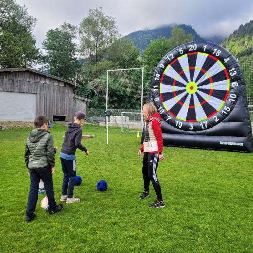 Kinder schießen auf große Dartscheibe mit Fußball 2