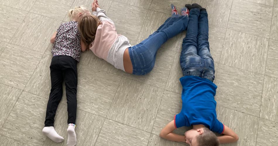 Kinder stellen Buchstaben mit Körper dar