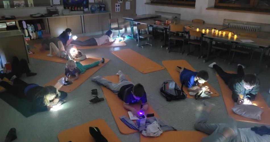 Kinder lesen mit Taschenlampen
