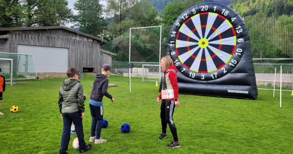Kinder schießen auf große Zielscheibe mit dem Fußball